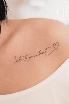 the back of a woman's shoulder with a tattoo that says listen to your heart