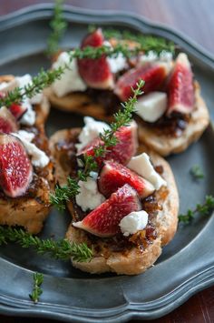 some food is sitting on a plate and garnished with fresh berries, cheese and herbs