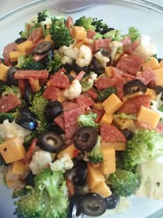 a salad with broccoli, cauliflower, olives and cheese