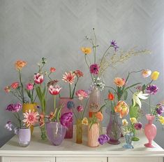 a table topped with vases filled with colorful flowers