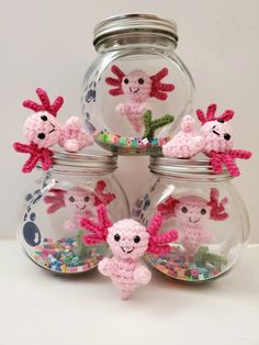 four crocheted sea animals are in a glass jar