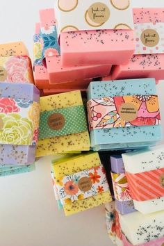 many different types of soaps stacked on top of each other with tags attached to them