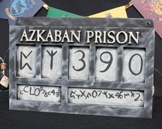 a metal sign that reads azkaban prison and has been altered to look like an old time clock