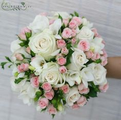 a bouquet of white and pink flowers is held by someone's hand on the floor