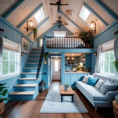 a living room filled with furniture and a stair case next to a window on the wall