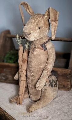 a stuffed rabbit holding a carrot on top of a table