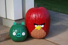 two pumpkins with angry birds painted on them sitting next to each other in front of a house