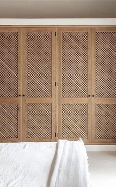 a white bed sitting in front of wooden closets