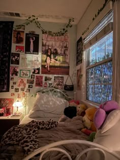 a bedroom with many pictures on the wall and a bed in front of a window