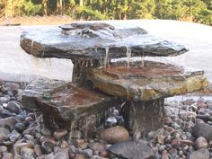 an outdoor fountain with rocks and water flowing from it