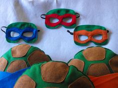 three turtle masks and one mask with red, orange, blue, and green colors