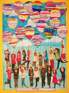 a group of children holding up balloons in the air