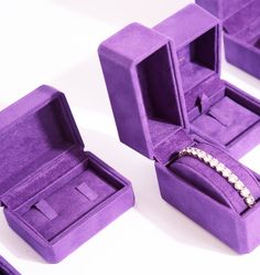 three purple velvet jewelry boxes with one open and the other closed