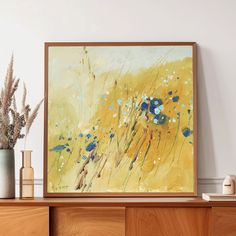 a painting is hanging on the wall next to some vases with flowers in them