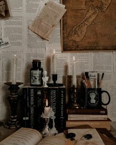 an open book sitting on top of a table next to some candles and bookshelves