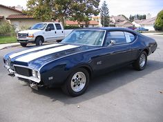 a blue and white muscle car parked in a parking lot