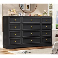 a black dresser with gold knobs in a living room