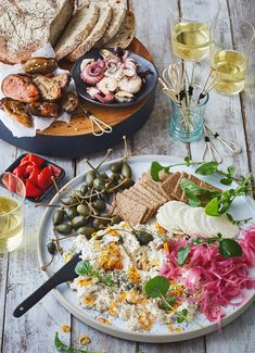 an assortment of food on a plate with bread, olives, and other foods