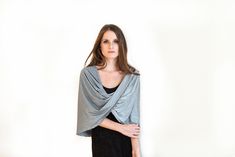 Step into a world of mesmerizing elegance with our Glittering Silver (Dark Gray) Loop Shawl - a captivating and lightweight accessory that effortlessly enhances your look in four different ways: as a shrug, shawl, crisscrossed shawl, or scarf. The captivating dark gray hue with a touch of shimmer exudes sophistication and versatility, making it a perfect choice for various occasions. Available in three sizes for a flawless fit: Petite (US 0-6) One size (US 8-14) Plus size (US 14-22) - Out of stock This exquisite shawl comes with wearing instructions, beautifully presented in a printed gift bag, making it a thoughtful and charming gift option for your loved ones. Additionally, we've thoughtfully included a QR code linked to the movie clip, granting you easy access to styling ideas. Experien Silver Shawl, Grey Shrug, Shrug For Dresses, Poncho Wrap, Elegant Scarves, Wrap Shawl, Party Tops, Shawls And Wraps, Scarf Styles