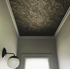 the ceiling in this bathroom is painted black and gold