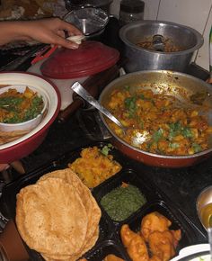 several dishes of food are being prepared on the stove