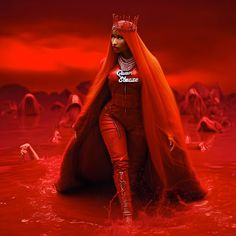 a woman in red is standing in the water with her hair flowing over her head