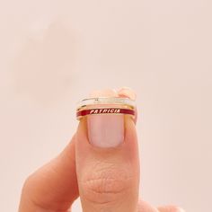 a woman's hand holding a ring with the word patticia on it