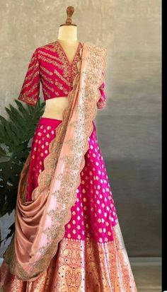 a mannequin dressed in a pink and gold lehenga