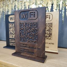 two wooden plaques with qr - code designs on them sitting on a table next to each other