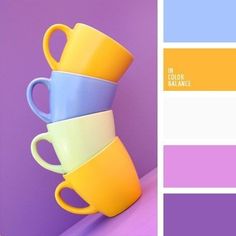 three coffee mugs stacked on top of each other in different shades of purple, yellow and blue