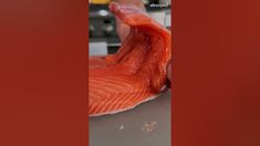 a piece of salmon being cut into pieces