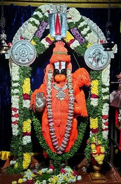 the idol is made up of flowers and other things in front of him on display