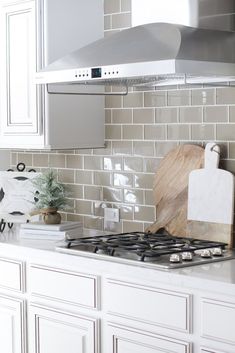 a stove top oven sitting inside of a kitchen next to white cabinets and counter tops