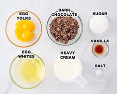 ingredients to make chocolate pudding laid out on a white counter top, including eggs, milk, sugar and vanilla