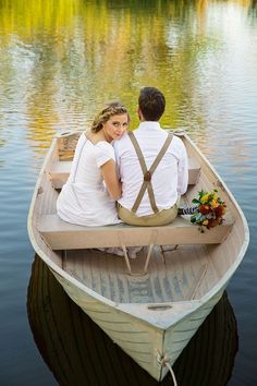 a man and woman are sitting in a boat on the water, looking at each other