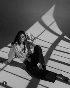 a woman is sitting on the floor with her legs crossed and looking at the camera