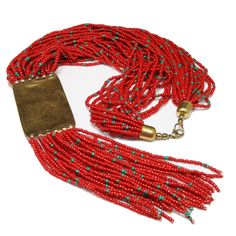 *Description: Bohemian beautiful red Czech seed bead multi-strand tribal fringe necklace with a brass pendant and glass inlay design from the 1970s. The red seed beads have teal blue seed beads scattered throughout the design. The beads are on white thread and have brass end caps. The enamel pendant and fringe are 6 1/2 Inches in length. This would be a great addition to your vintage jewelry collection or make a great vintage gift! *Approximate Measurements: Length - 21 Inches, Pendent Length (w Traditional Red Beaded Fringe Jewelry, Artisan Red Beaded Necklace With Dangling Beads, Red Multi-strand Dangling Beads, Red Multi-strand Beads For Festival, Artisan Multi-strand Red Beads, Artisan Red Dangling Beads, Bohemian Multi-strand Red Beads, Inlay Design, Bead Fringe