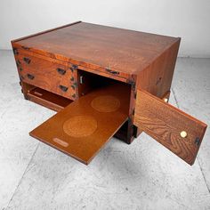 a wooden desk with two drawers open on the top and one drawer opened to reveal something inside