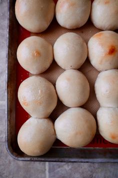 several balls of bread sitting on top of a baking sheet in a metal pan, ready to be baked