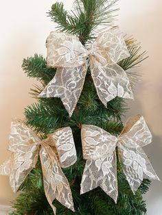 a christmas tree decorated with white lace and bows