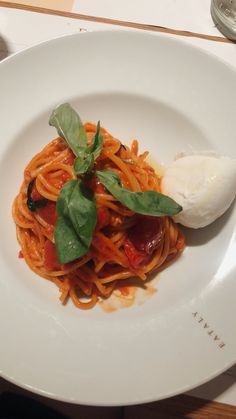 a white plate topped with pasta and sauce