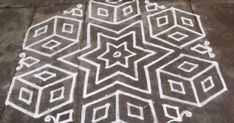 a drawing on the ground that looks like it is made with white chalk and has geometric shapes