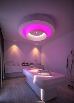 a large white bath tub sitting under a purple light