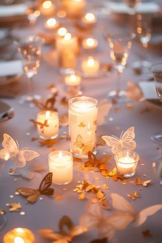 many lit candles are on the table with butterflies