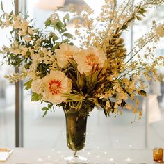 a vase filled with lots of flowers on top of a table