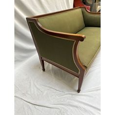 a green chair sitting on top of a white cloth covered floor next to a guitar