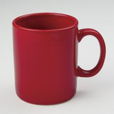 a red coffee cup sitting on top of a white table