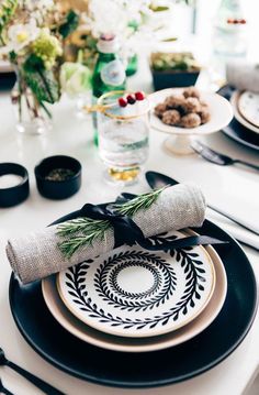 a table set with plates, napkins and silverware for an elegant holiday dinner