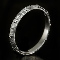 an intricately engraved wedding ring on a black background