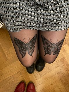 two women with tattoos on their legs and one has a butterfly tattoo on her leg